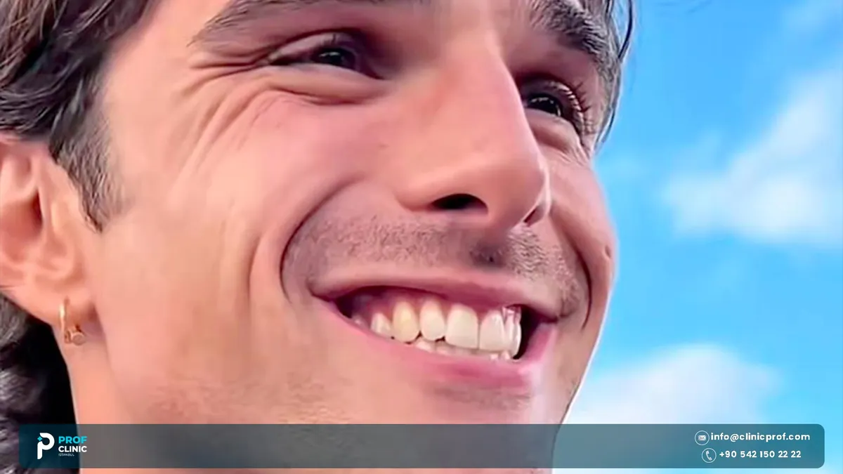 صورة من زاوية منخفضة لجاكوب إلوردي مبتسماً أمام سماء زرقاء