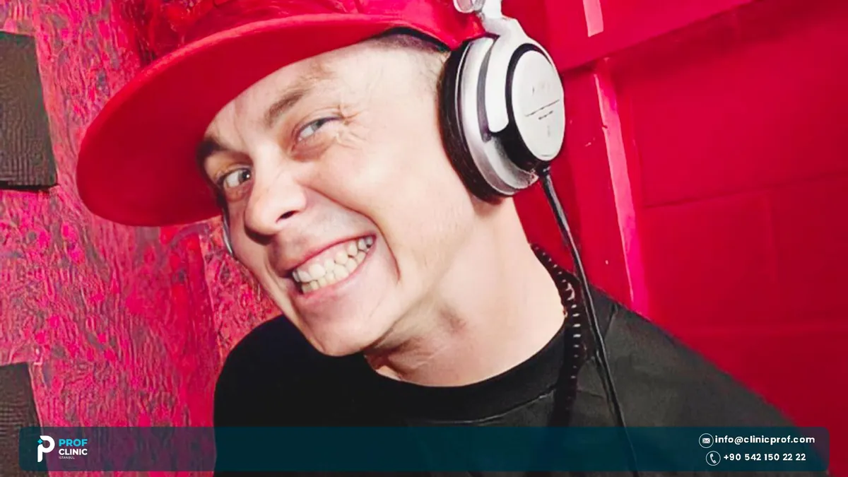 Sid Wilson grinning in a red cap and headphones in a red room