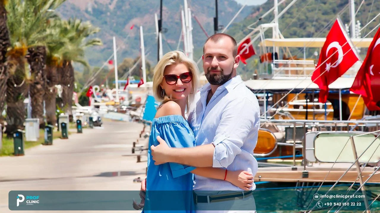 Tourist couple embracing at a harbour with Turkish flags on the boats behind them