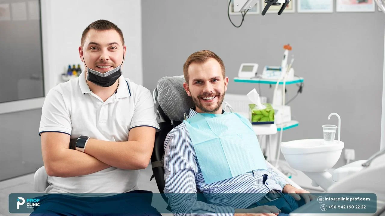 Two smiling men in a dental clinic, one of them sitting in the dental chair
